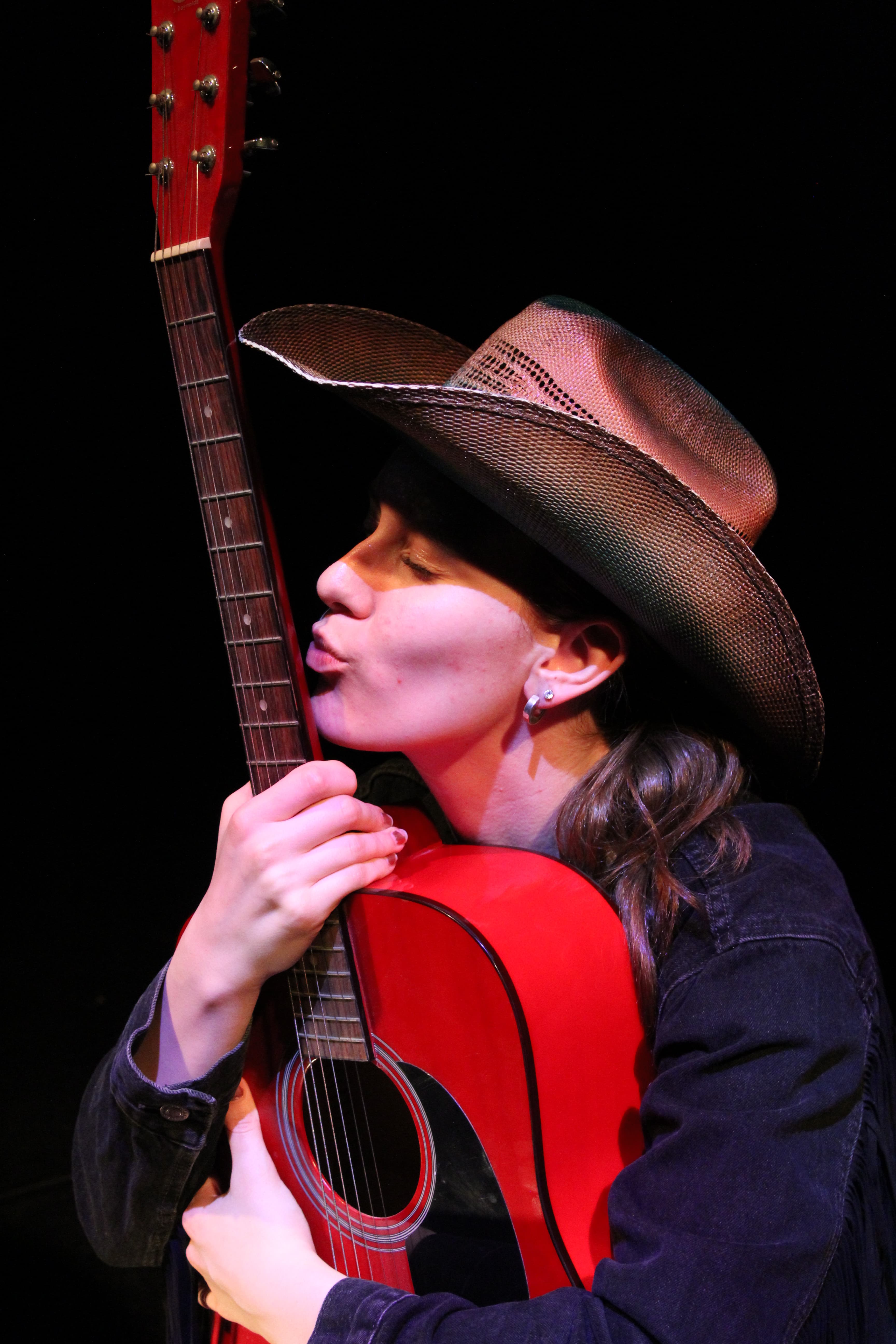 Maya performing with a guitar on stage