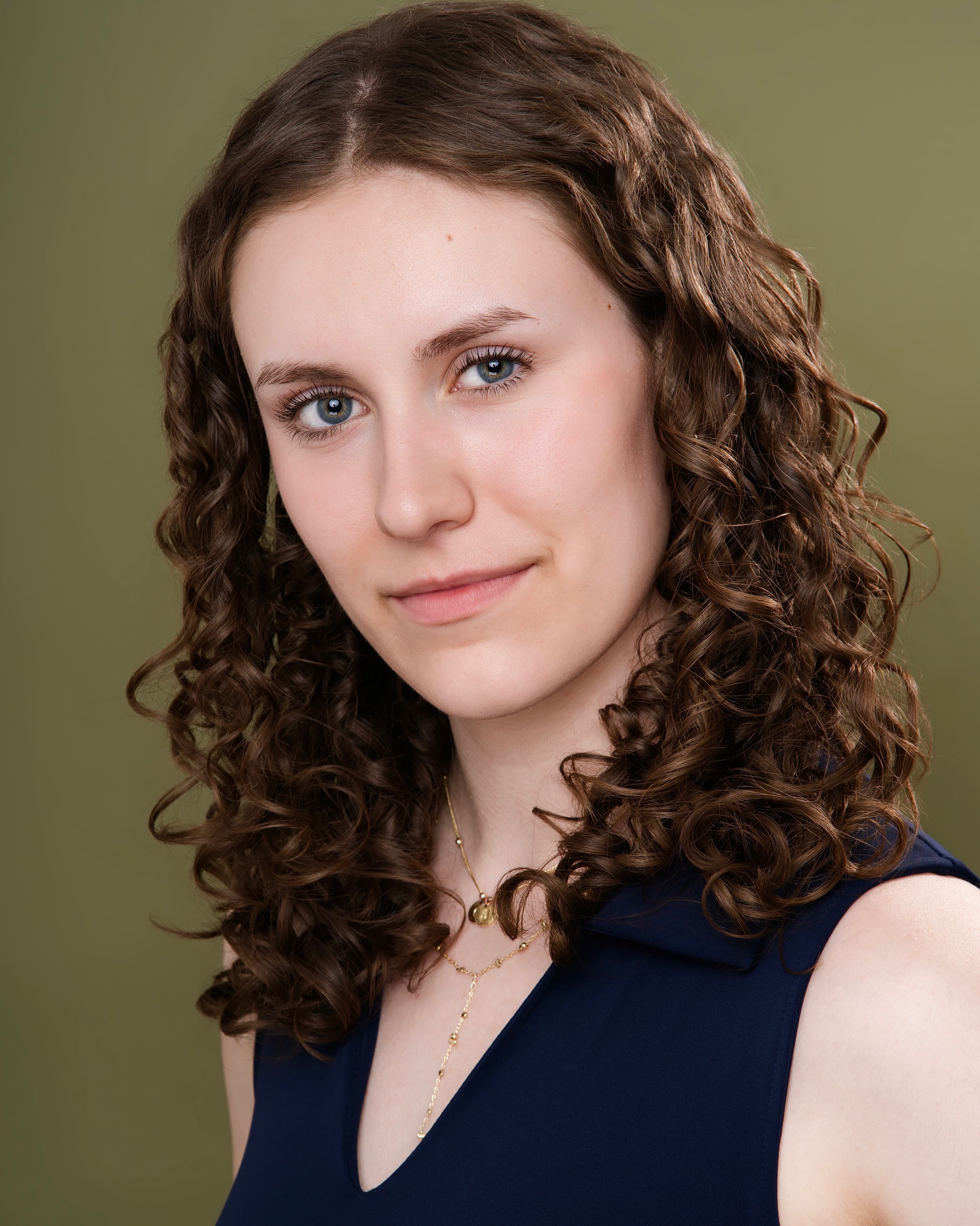 Maya Cassell theatrical headshot on an olive backdrop