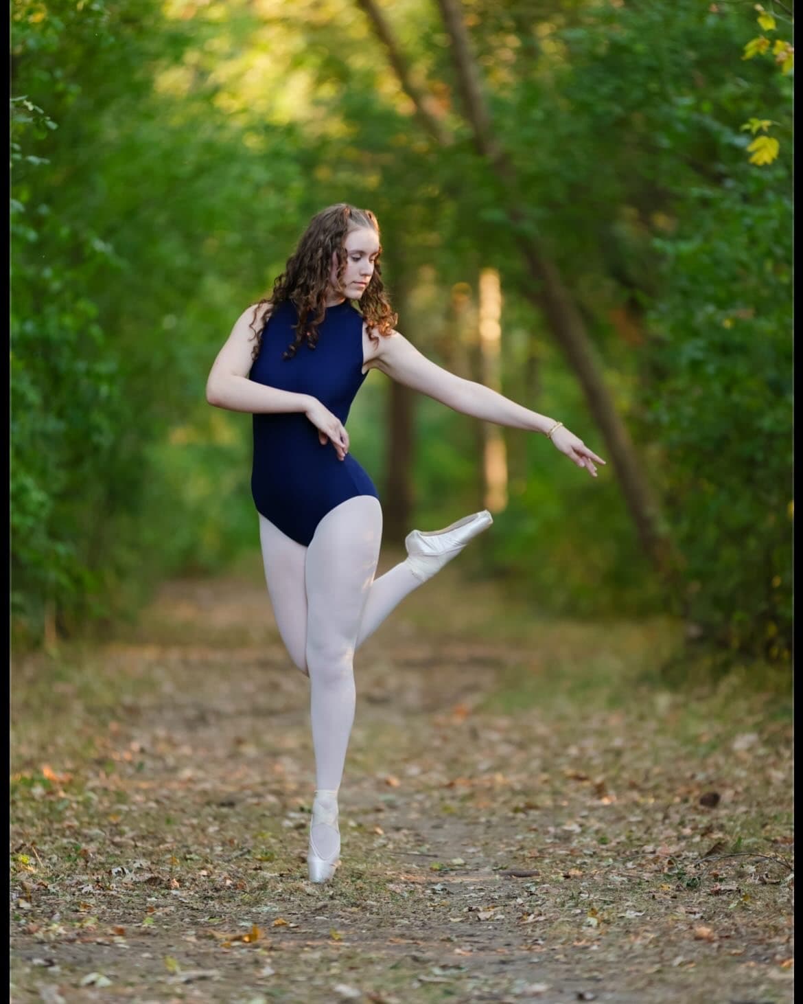 Maya en pointe on a wooded path